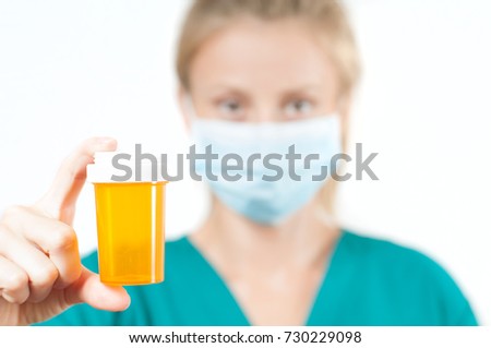 Female doctor, nurse holding a pill on white background.