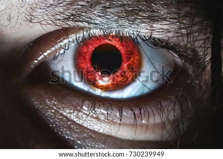 Eye close-up with a red pupil on a halloween horror
