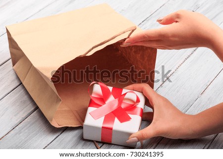 Beautiful gift boxes with a red and white bow on a wooden background.