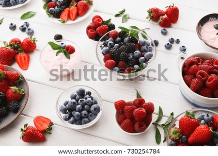 Healthy breakfast background. Light greek yogurt, fresh strawberries, raspberries, blueberries and blackberries. Low fat morning meals and healthy start of the day. Detox and eating right concept