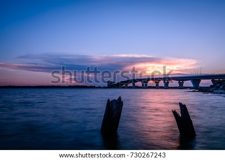 Sunset at the Hathaway Bridge connecting Panama City and Panama City Beach, Florida. Royalty-Free Stock Photo #730267243