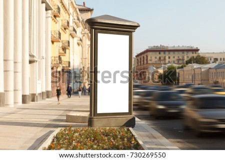Blank vertical street advertising pillar with city background. 