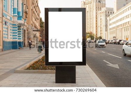 Blank vertical street billboard stand with city background. 