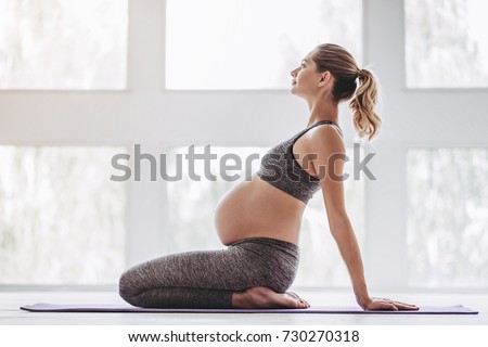 Beautiful pregnant woman workout. Doing fitness on last months of pregnancy. Yoga positions. Royalty-Free Stock Photo #730270318