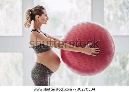 Beautiful pregnant woman workout. Yoga with fitball. Doing fitness on last months of pregnancy. Royalty-Free Stock Photo #730270504
