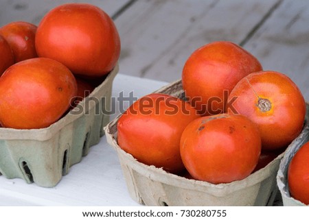 Tomatoes inside cartons on top of a table.