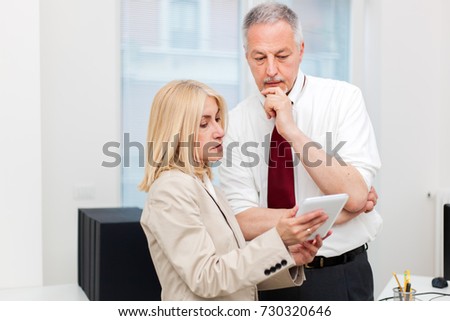 Business colleagues using a tablet in their office