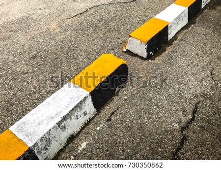 Yellow And White Street Curbs On The Broken Asphalt Road 