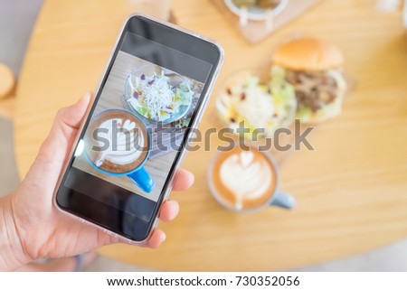 hand hold phone take brunch picture with salad and coffee