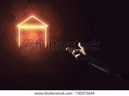 Male hand pointing to the glowing home icon or symbol