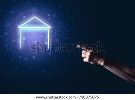 Male hand pointing to the glowing home icon or symbol