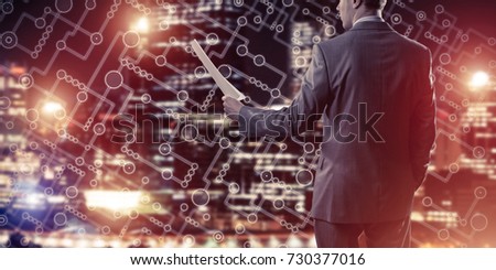 Businessman standing with back and holding contract or report in his hand