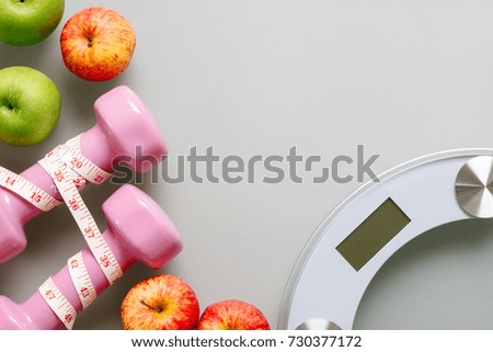 Fitness and healthy active lifestyle dieting background concept. Dumbbell, weight scales, apples, bananas on clean background. Top view with copy space.