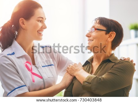 Pink ribbon for breast cancer awareness. Female patient listening to doctor in medical office. Raising knowledge on people living with tumor illness. Royalty-Free Stock Photo #730403848