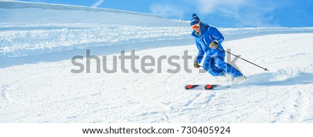 Young athlete skiing in alps mountains on sunny day - Skier riding down for winter snow sport competition - Training and vacation concept - Man focus on man head - Warm vivid filter Royalty-Free Stock Photo #730405924