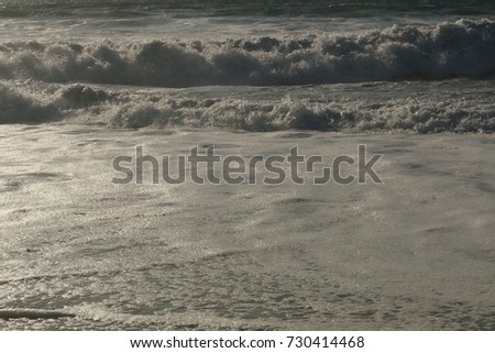 Ocean sand and bubbles of passing waves, foam of the waves, Reflection of the sun, Pacific Ocean, California