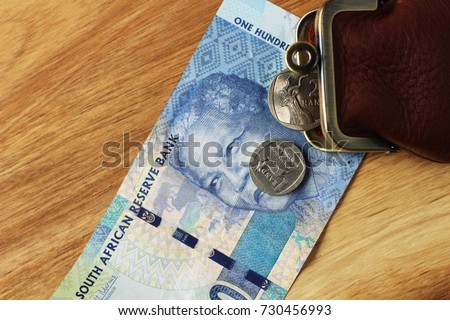 South African money on a wooden table top.