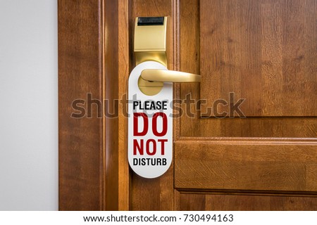 Entrance door of hotel room with sign please do not disturb