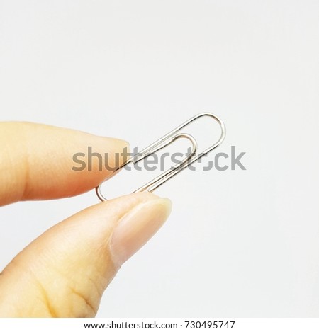 Paperclips, colorful clips, isolated background. The finger catch paperclip.