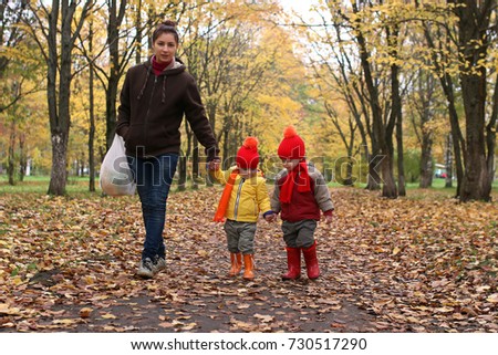 kids in autumn park with pumpkin around fall leaves