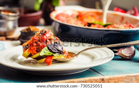 Ratatouille - a classic vegetarian dish from French cuisine. Vegetable stewed. Blue wooden table. Baked vegetables in tomato sauce with basil and paprika.comfort vegan food concept. Selective focus. Royalty-Free Stock Photo #730525051