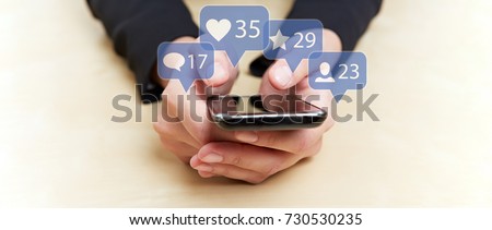 Hands holding smartphone with social media or social network notification icons Royalty-Free Stock Photo #730530235
