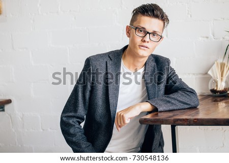 Smartly dressed businessman, smiling while stand near wall