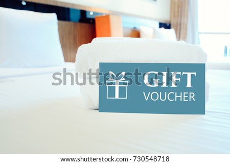 Gift voucher concept. Gift voucher card placed inside a hotel room bed with White towel.