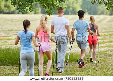 Young people in hiking club nordic walking in the nature