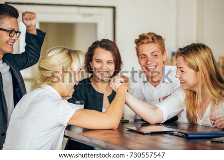 two woman armwrestling, exerting pressure on each other, looking eyes in eyes, struggling for leadership. Business, society concept photo