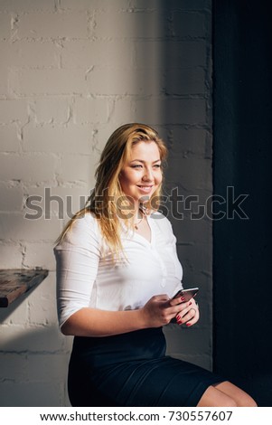 beautiful young woman using an application to send an sms message in her smartphone device