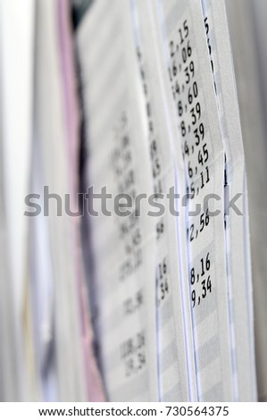 Part of a payroll with focus on black figures and blur around on the other paper sheets