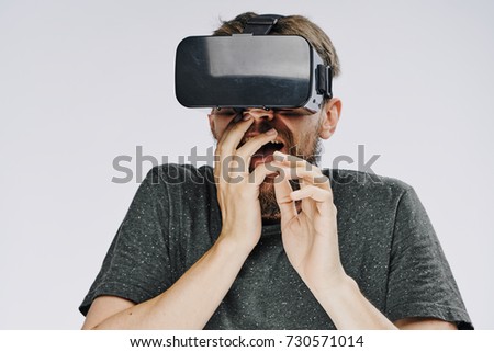 man surprised playing games in 3d glasses on a light background                               
