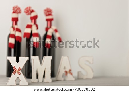 Merry Christmas and a Happy New Year! Bottles of wine in a knitted cap of Santa Claus. Selective focus.