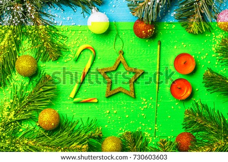 Image of blue wooden table with spruce branches, figures from caramel, candles, Bengal lights, colorful balls