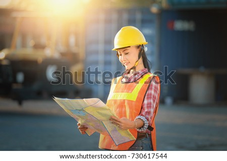Woman engineering on transportation site map on during sunset,Woman engineer reading map on site,