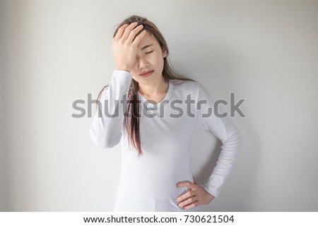 Asian woman is unhappy with headaches due to stress.