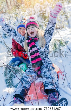 Girl and girl playing in big snow in winter. Happy caucasian child playing in snow forest