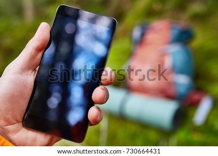 Tourist taking a picture of forest using a smartphone
