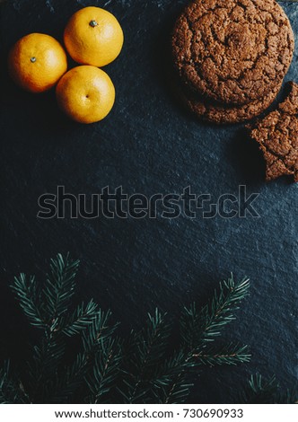 Cookies and orange on the black stone background