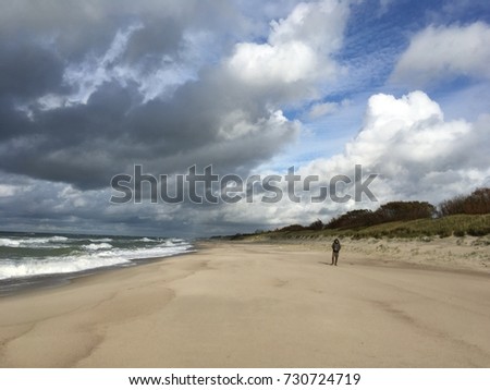 The sandy beach, Atmospheric scenery Dramatic Baltic sea, waves and water splashes on breakwaters. Nature north cloudscape on coast ocean. Environment with fickle weather, climate change. Stormy