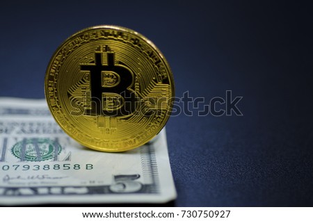 Golden Bitcoins on banknotes background.Photo of golden bitcoin (new virtual currency)