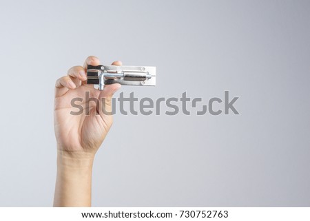 Hand holding shiny silver color stainless steel door bolt lock or latch on white background