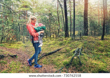 mother walking in the woods with baby in kangaroo bag