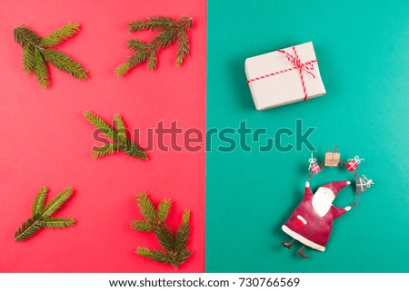 Christmas background. Fir tree branch, xmas decoration and small gift box on red and green background. Top view
