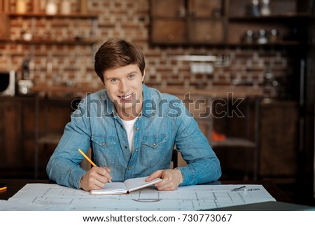 Handsome man posing while doing project calculations