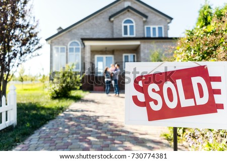 sold house with blurred family on background Royalty-Free Stock Photo #730774381