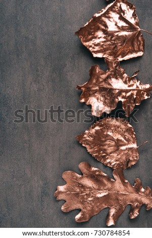 Fall rose gold colored leaves flatlay on dark background, creative concept. Copy space for text