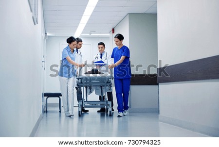profession, people, health care, reanimation and medicine concept - group of medics or doctors carrying unconscious woman patient on hospital gurney to emergency Royalty-Free Stock Photo #730794325