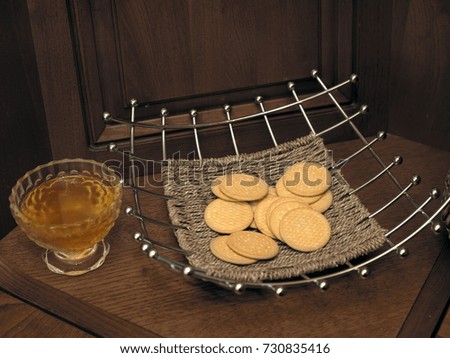 Round biscuits laid in a vase on a top of kitchen shelf, indoor cropped photo